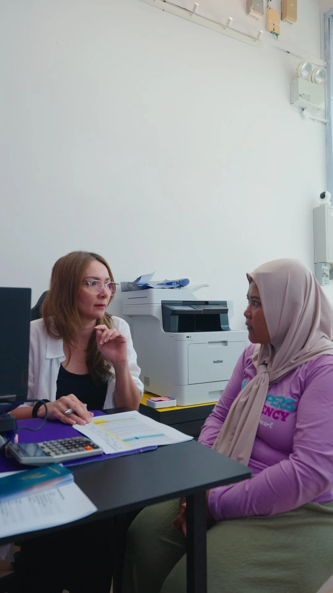 A Jaz Helpers consultant going through paperwork with a helper at the office