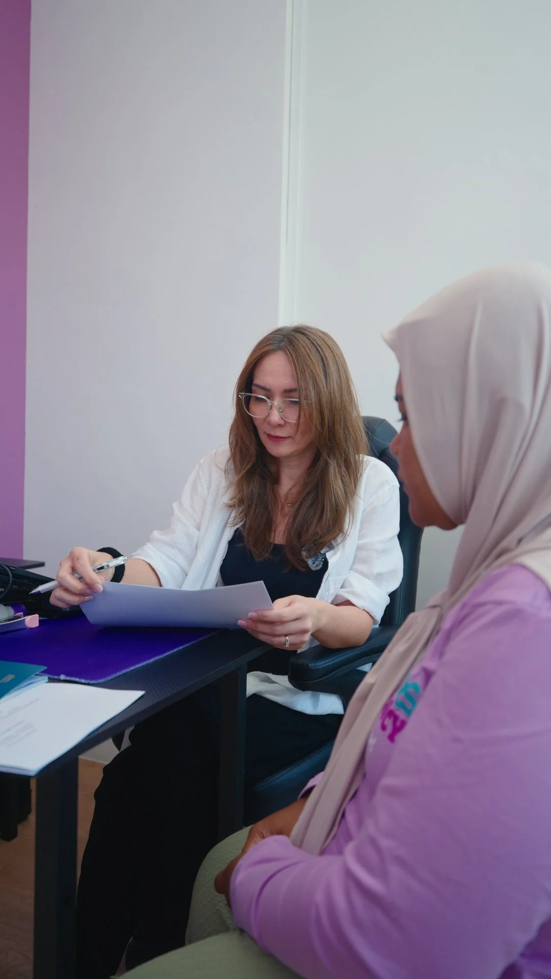A Jaz Helpers consultant going through paperwork with a domestic helper at the office