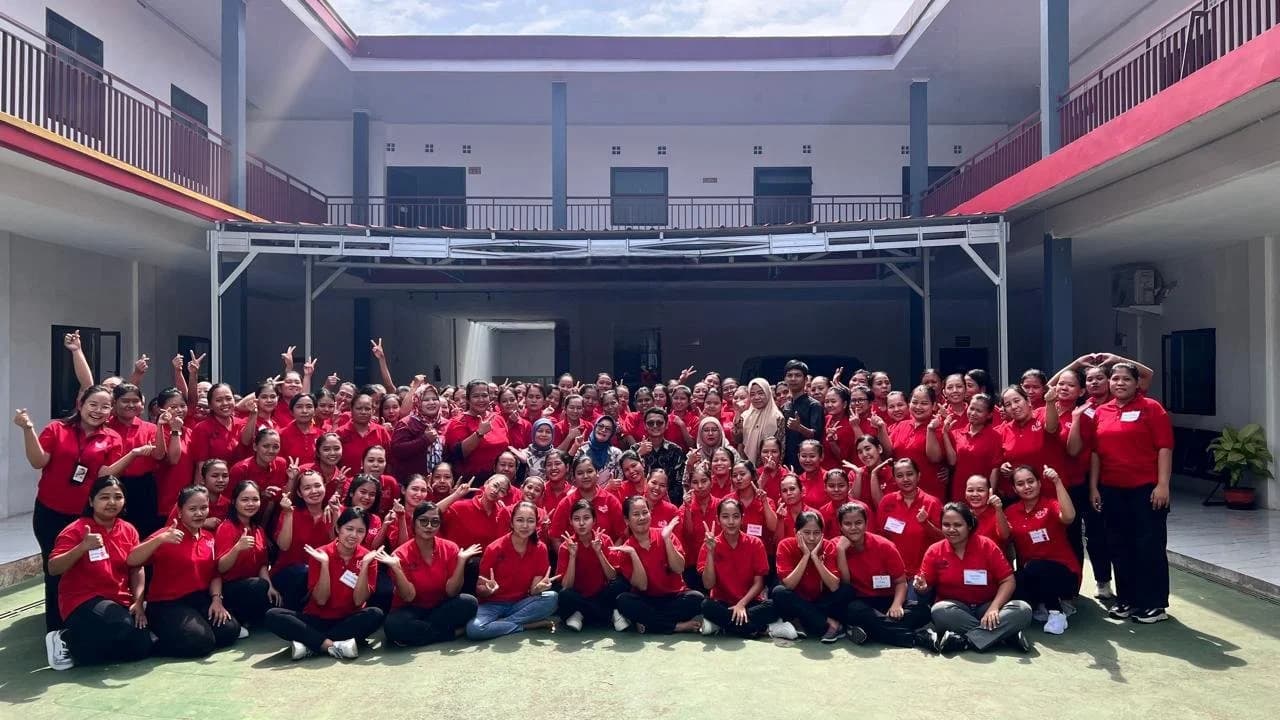 A large group of trainee domestic helpers photographed in the courtyard of a partner training centre